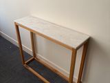 a wooden table with a marble top in the corner of a room