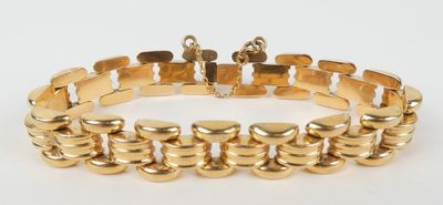 gros plan d'un bracelet en or sur fond blanc