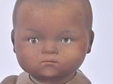 a baby doll that is sitting on a white surface