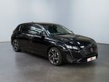 a black car is parked in a large room with a white wall