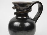 une image représentant un vase noir muni d'une anse incurvée sur fond blanc