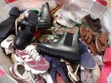 many pairs of shoes in a basket on the floor
