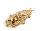 a gold plated pendant with a lion on it ' s back