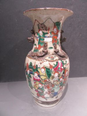 a vase with a painting on it sitting on a table