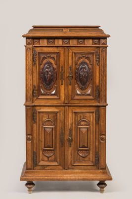 une vieille armoire en bois ornée de sculptures sur le dessus