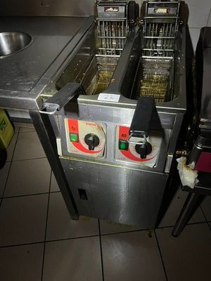 deux friteuses posées sur un plan de travail dans une cuisine