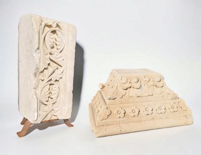 two pieces of carved stone with carvings on them on a white surface