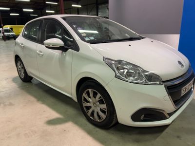 une voiture blanche garée dans un garage, avec d'autres voitures en arrière-plan