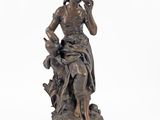bronze statue of a woman sitting on a rock with a dog
