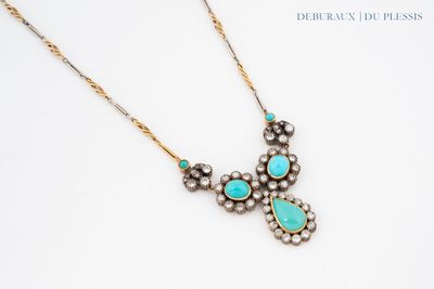 a necklace with turquoise stones and pearls on a white surface