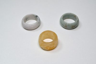 trois anneaux de couleurs différentes posés sur une surface blanche