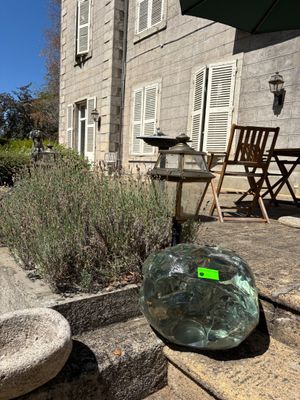 a glass vase sitting on the steps outside of a house