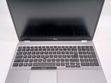 a silver laptop with a black keyboard on a white surface