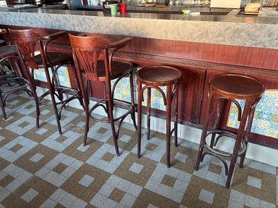 four wooden stools sitting at the bar of a restaurant
