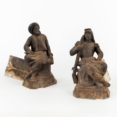 paire de figurines en bois sculpté représentant un homme et une femme assis sur un rocher