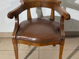 a brown leather chair sitting on a tile floor