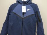 the nike jacket is hanging on a hanger in a room