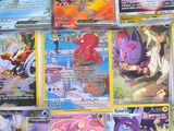 a lot of different pokemon cards on the table