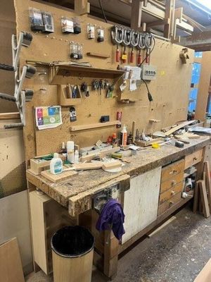un établi dans un atelier, sur lequel sont posés de nombreux outils