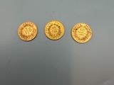 three gold coins, one of which has a crown and the other of which has a crown on it