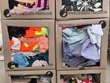 un chariot sur lequel sont empilées de nombreuses boîtes de vêtements