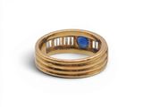 a close up of a gold ring with a blue stone in it