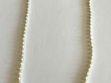 gros plan d'un collier de perles sur une surface blanche