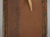 an old picture frame with a yellow ribbon hanging from it ' s side