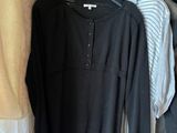 three shirts hanging on a rack in a room with clothes
