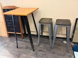 three stools and a table in a room with a chalk board