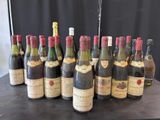 Plusieurs bouteilles de vin sont alignées sur une table devant un fond noir.