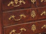 a brown chest of drawers with gold decorations on it
