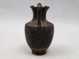 a black vase that is sitting on a white surface