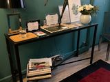 une table avec des livres et une lampe dans une pièce