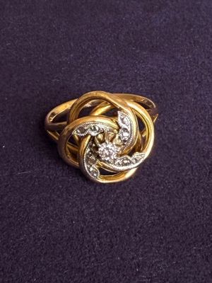 an image of a gold and diamond ring on a purple surface