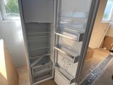 an open refrigerator in the middle of a room with a window