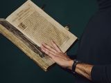 a man that is holding a book in his hands