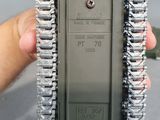a hand holding a small tank that has a red handle