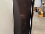 a black refrigerator sitting on a pallet in a warehouse