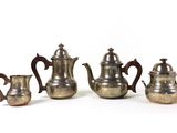 trois théières en argent et une cafetière posées les unes à côté des autres
