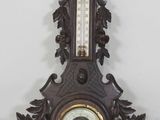 une horloge accrochée au mur, sur laquelle se trouve un thermomètre