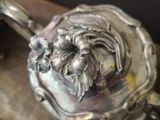 a silver teapot with a lion head on top of it