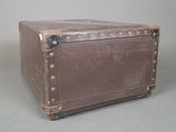 a brown suitcase sitting on a table with a gray background