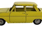 une petite voiture jaune posée sur une surface blanche, elle-même posée sur une surface blanche