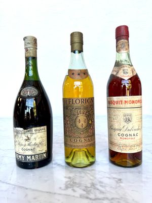 three bottles of liquor sitting on a marble table