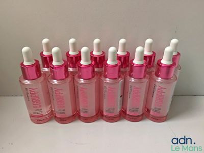 un gros plan sur un ensemble de bouteilles contenant un liquide rose et blanc