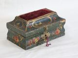 a small green box with a red velvet lid