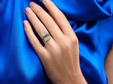 the woman is wearing a blue dress and a diamond ring