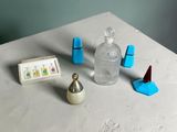 a table with a small bottle of liquid and a small object