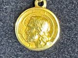 an image of a gold coin on a chain on a table